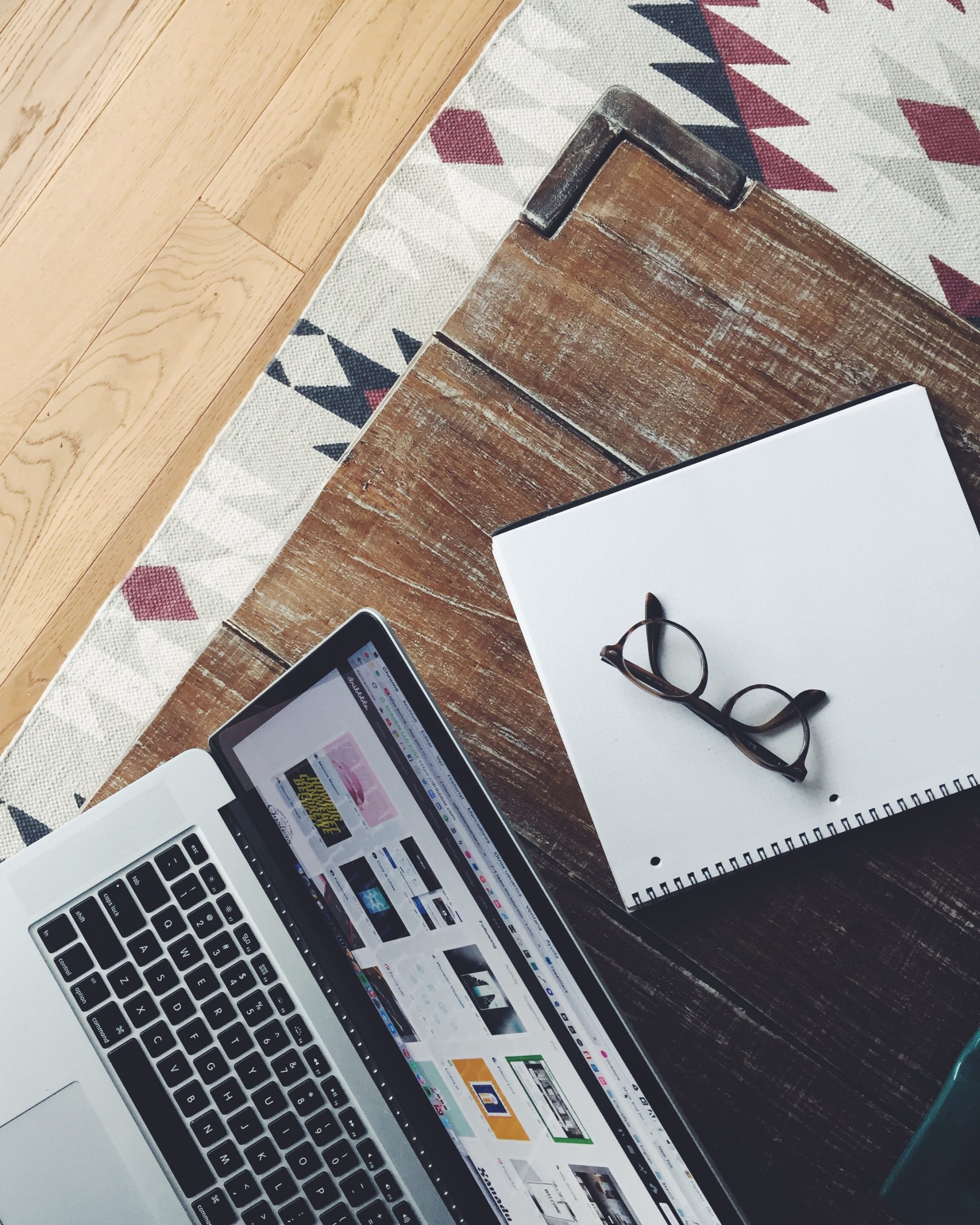 laptop with open notebook and glasses